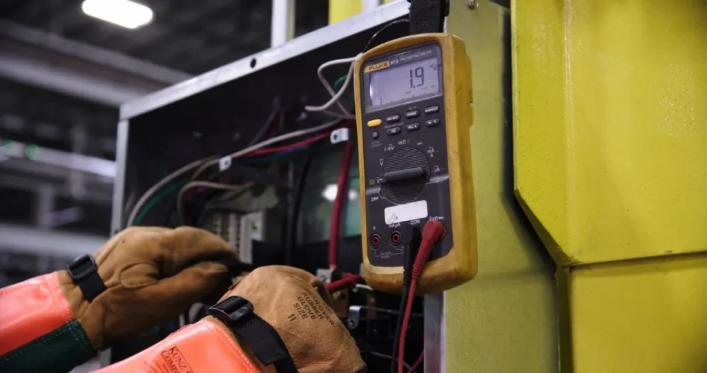 Electrician using a multimeter to test electrical wiring and connections